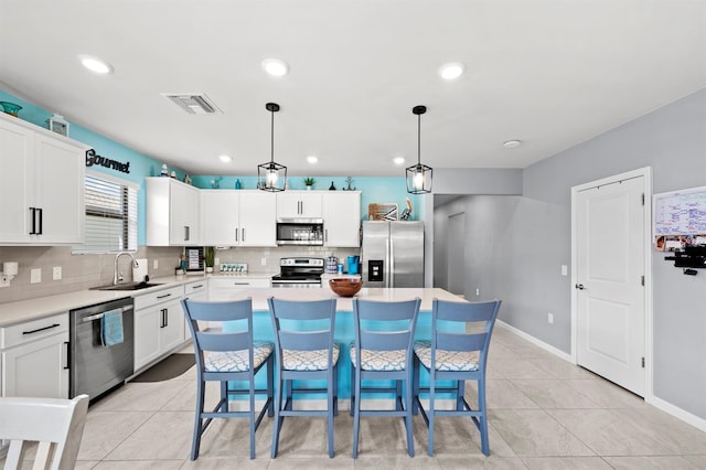 16016 Shoebutton Ct, North Fort Myers, FL 33917 - kitchen featuring appliances with stainless steel finishes, a sink, light countertops, decorative backsplash, and visible vents