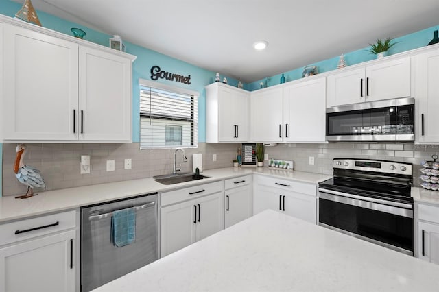 16016 Shoebutton Ct, North Fort Myers, FL 33917 - kitchen with a sink, appliances with stainless steel finishes, backsplash, and white cabinetry