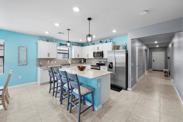 16016 Shoebutton Ct, North Fort Myers, FL 33917 - kitchen featuring appliances with stainless steel finishes, a sink, light tile patterned floors, a kitchen island, and visible vents