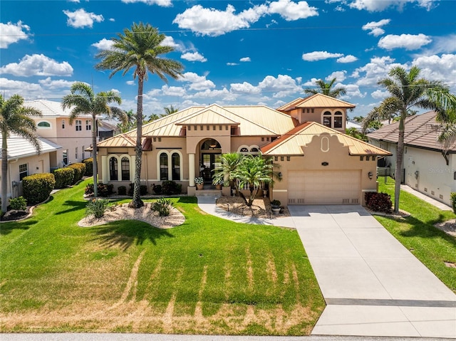 mediterranean / spanish-style home featuring stucco siding, concrete driveway, a garage, and a front lawn