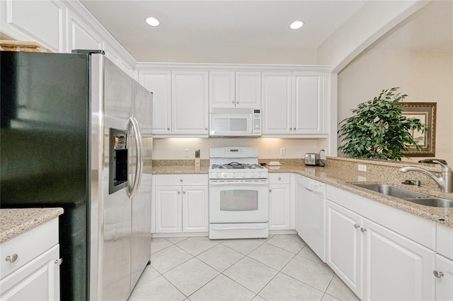 kitchen with white appliances, a sink, light tile patterned flooring, white cabinetry, and recessed lighting