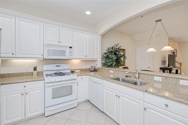 kitchen featuring white appliances, a sink, arched walkways, light tile patterned floors, and white cabinetry