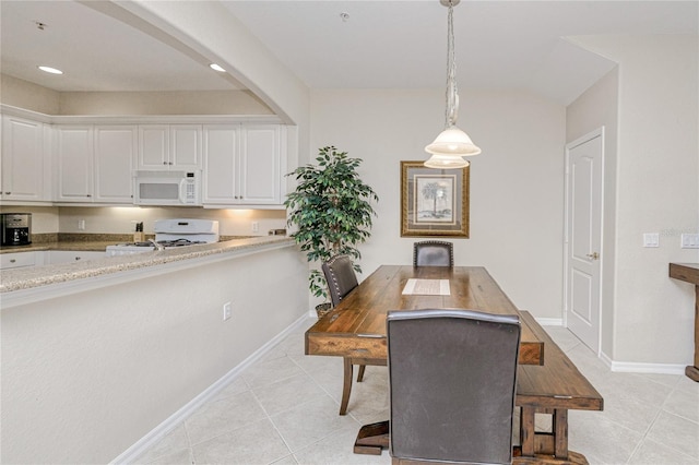 dining area with light tile patterned floors, baseboards, arched walkways, and recessed lighting