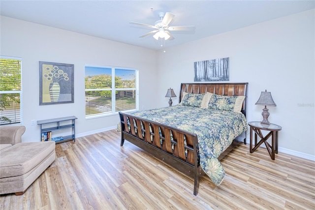 bedroom featuring baseboards, multiple windows, and wood finished floors