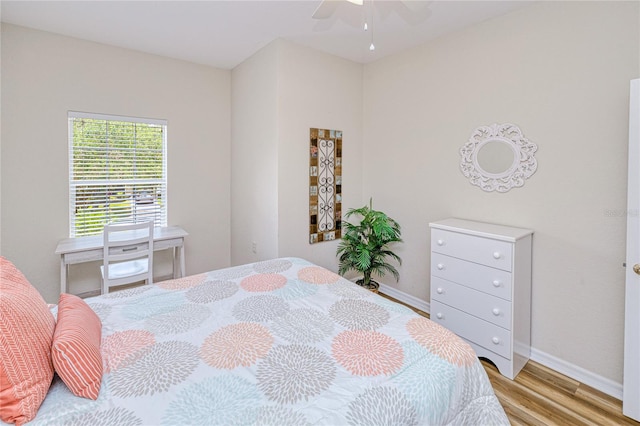 bedroom with light wood finished floors and baseboards