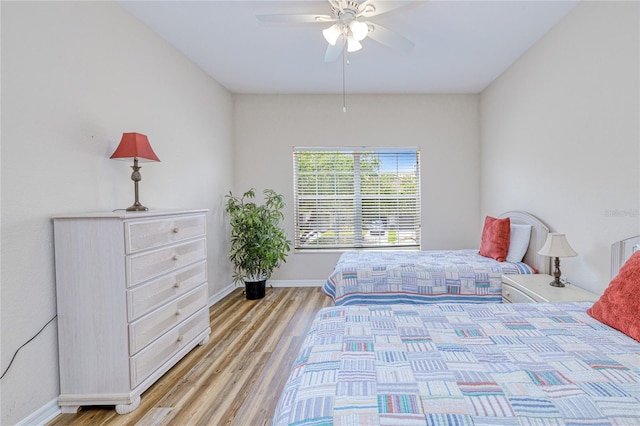 bedroom featuring light wood-type flooring, baseboards, and ceiling fan