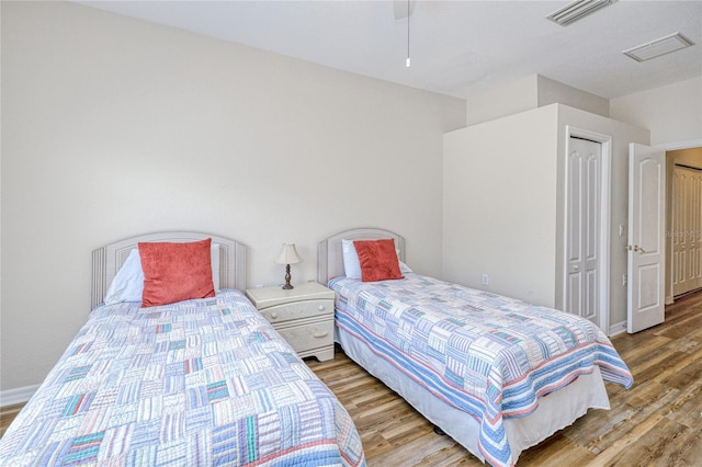 bedroom featuring wood finished floors, a ceiling fan, and baseboards
