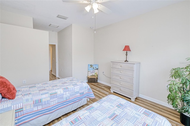 bedroom with wood finished floors, baseboards, and ceiling fan