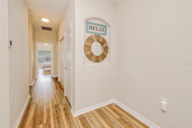 hallway with light wood-style floors and baseboards