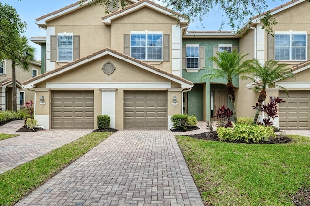 multi unit property featuring stucco siding, a garage, and driveway