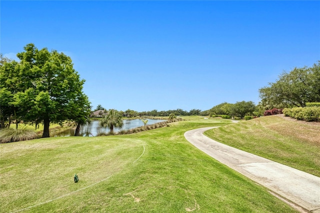 view of property's community with a water view and a yard