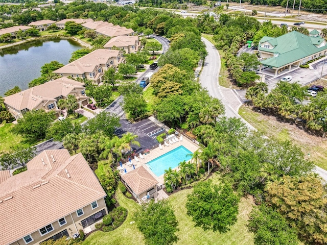 aerial perspective of suburban area with a pool and a nearby body of water