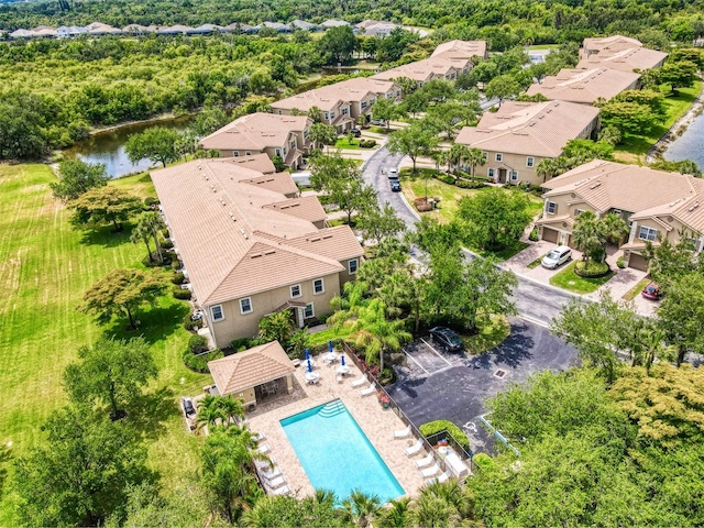 aerial view of residential area featuring a pool and a large body of water