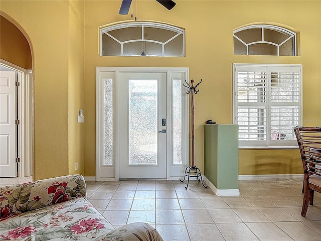 entrance foyer with healthy amount of natural light, light tile patterned floors, and a high ceiling