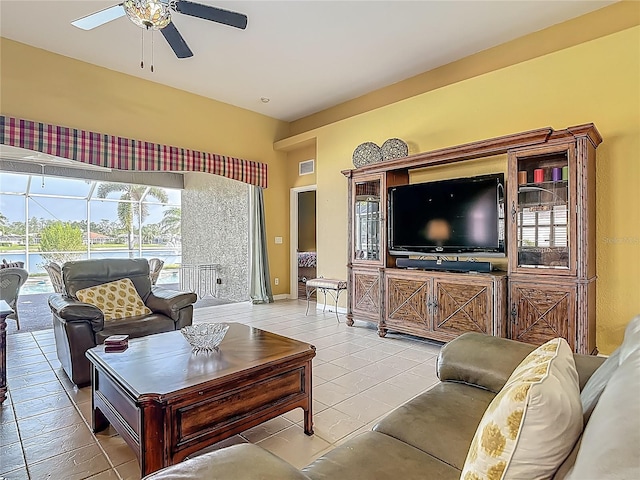living area featuring a ceiling fan, baseboards, and light tile patterned floors