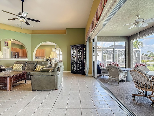 living area with ceiling fan and light tile patterned floors