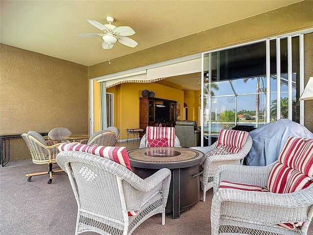view of patio / terrace with a ceiling fan and an outdoor fire pit