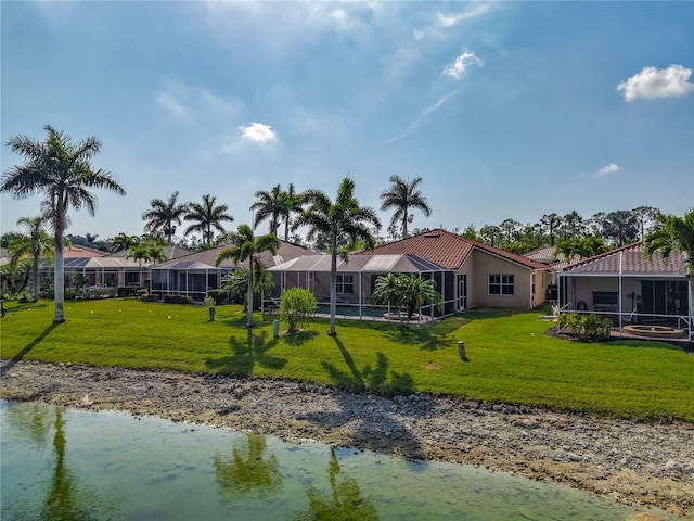 back of house featuring a water view, a lawn, and a lanai