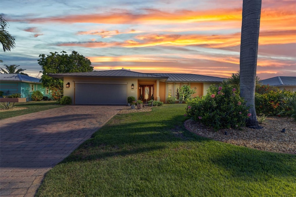 2100 Via Esplanade, Punta Gorda, FL 33950 - mid-century inspired home with stucco siding, a garage, a standing seam roof, and decorative driveway