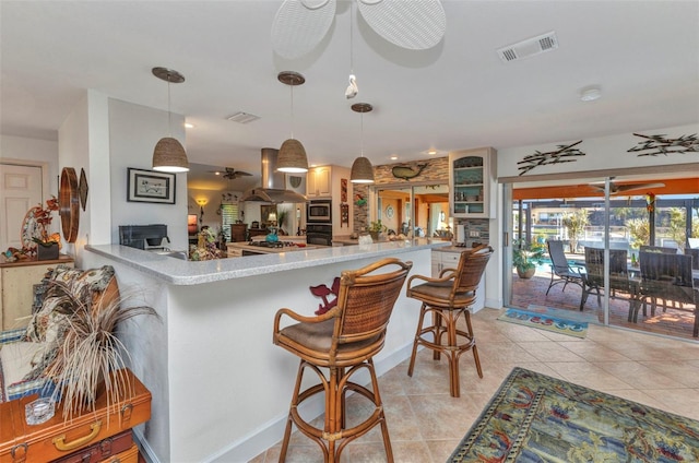 kitchen featuring exhaust hood, stainless steel microwave, black oven, light tile patterned floors, and ceiling fan