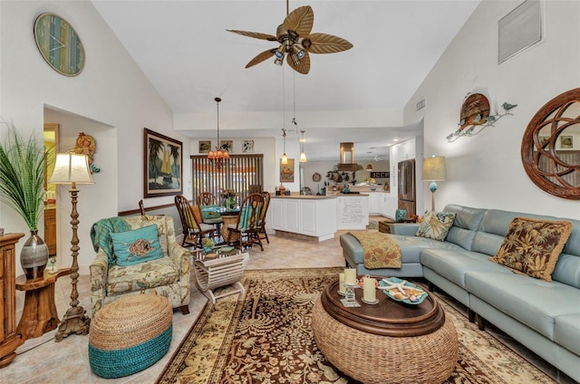 living room with a ceiling fan, high vaulted ceiling, and a chandelier