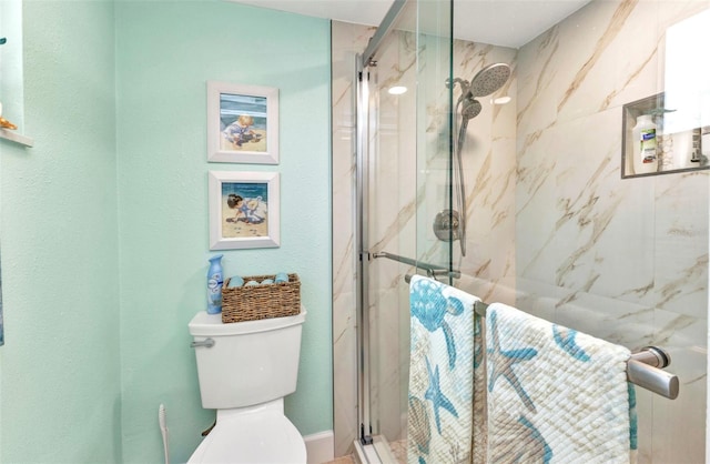 full bathroom with a marble finish shower and toilet