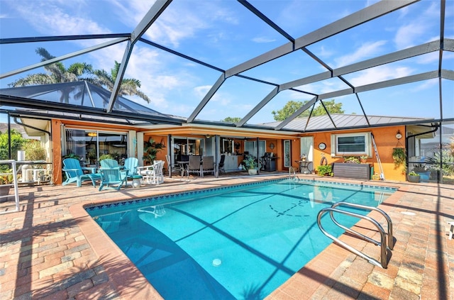 outdoor pool with a patio, outdoor dining space, a lanai, and area for grilling