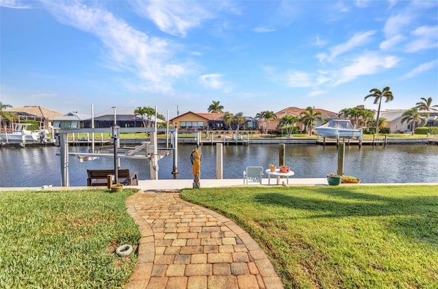 dock with boat lift, a residential view, a lawn, and a water view