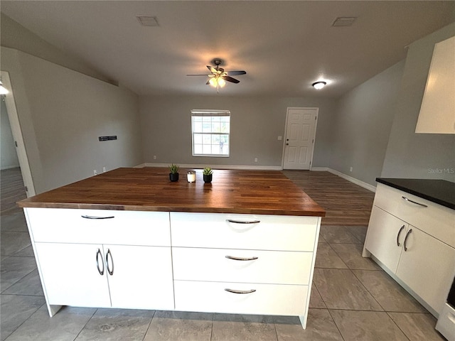 kitchen featuring open floor plan, visible vents, white cabinets, and ceiling fan