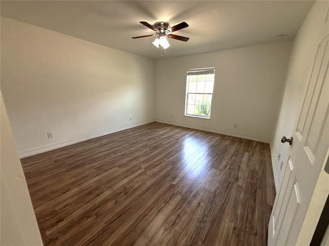 unfurnished room with dark wood-style flooring, baseboards, and ceiling fan