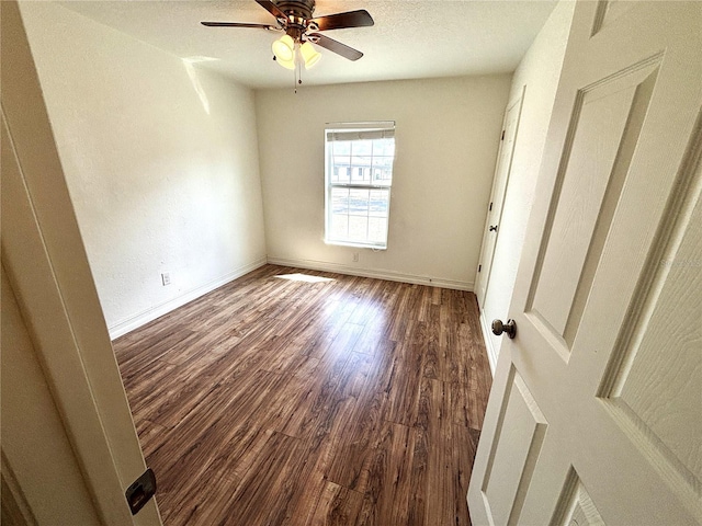 unfurnished room featuring baseboards, a ceiling fan, and wood finished floors