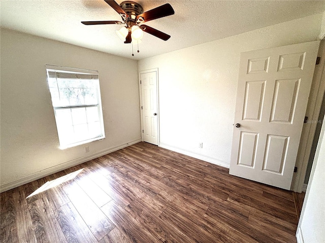 unfurnished bedroom with baseboards, dark wood finished floors, ceiling fan, and a textured ceiling