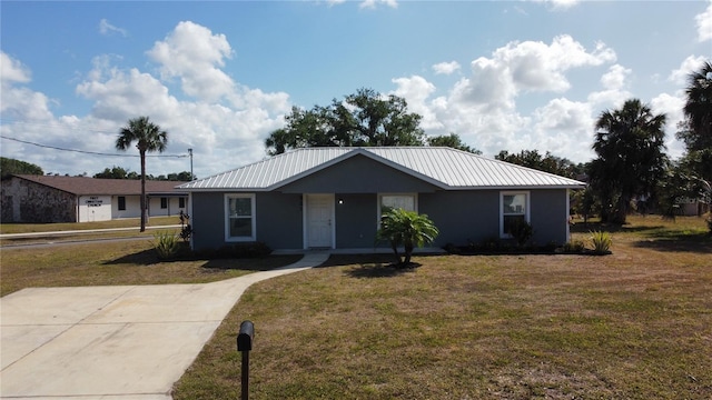 ranch-style home featuring metal roof and a front yard