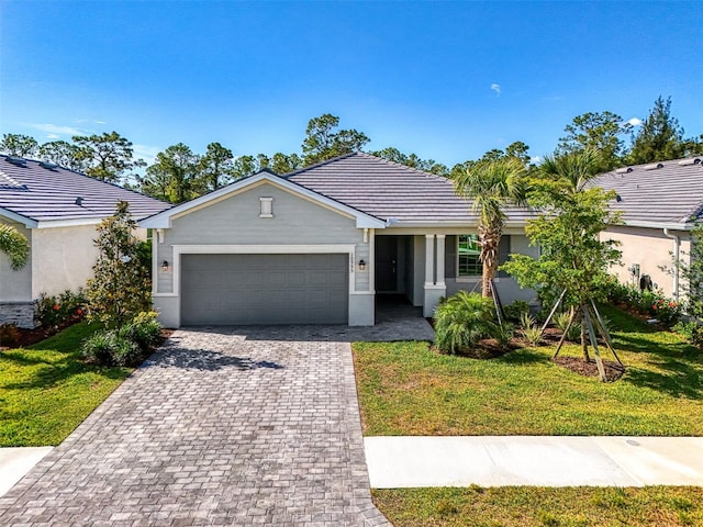 10995 Pinot Dr, Venice, FL 34293 - ranch-style house featuring an attached garage, decorative driveway, and a front yard
