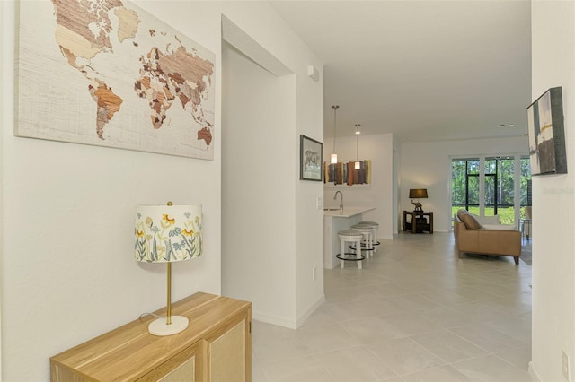 10995 Pinot Dr, Venice, FL 34293 - hall with baseboards, light tile patterned flooring, and a sink