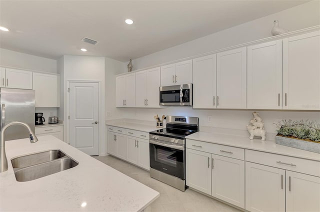 10995 Pinot Dr, Venice, FL 34293 - kitchen featuring stainless steel appliances, visible vents, a sink, white cabinetry, and light countertops