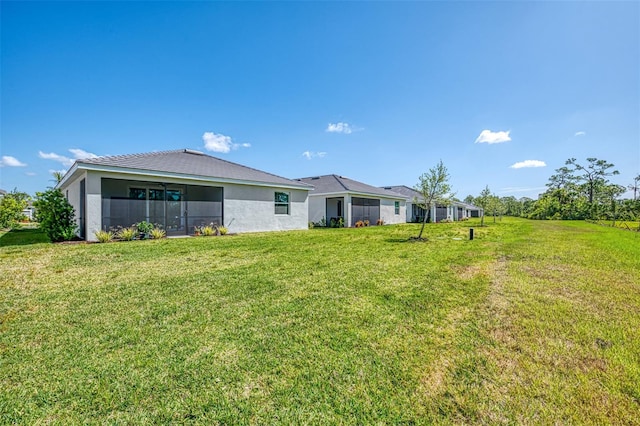 10995 Pinot Dr, Venice, FL 34293 - rear view of house featuring a lawn and stucco siding