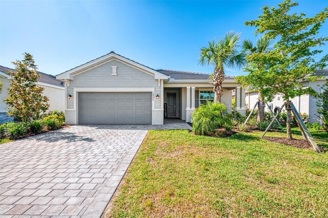 10995 Pinot Dr, Venice, FL 34293 - ranch-style home featuring a front yard, stucco siding, an attached garage, and decorative driveway