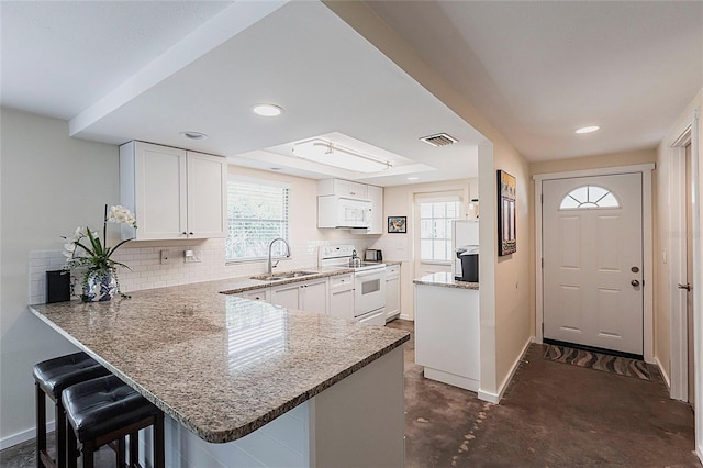 320 W Ann St, Punta Gorda, FL 33950 - kitchen featuring light stone countertops, baseboards, white appliances, visible vents, and a sink