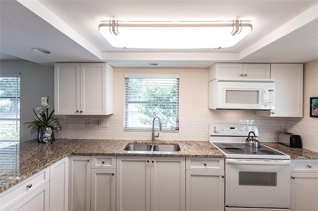320 W Ann St, Punta Gorda, FL 33950 - kitchen with white cabinetry, white appliances, a tray ceiling, and a sink