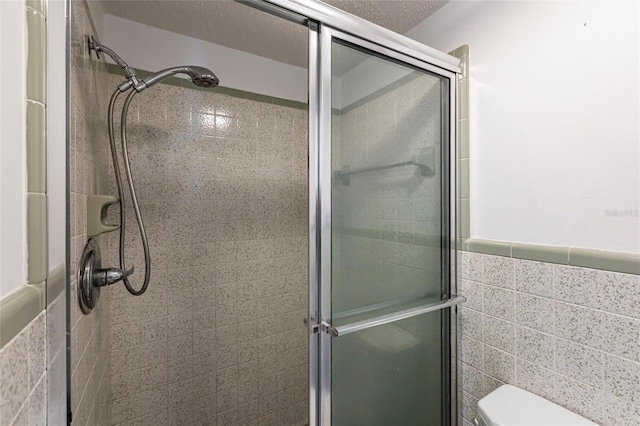320 W Ann St, Punta Gorda, FL 33950 - bathroom featuring a stall shower, tile walls, and toilet