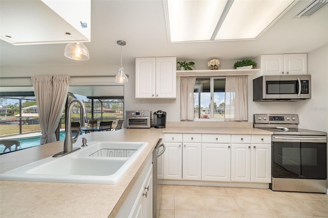 2331 Cannolot Blvd, Port Charlotte, FL 33948 - kitchen featuring stainless steel appliances, a sink, light tile patterned flooring, light countertops, and pendant lighting