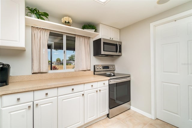 2331 Cannolot Blvd, Port Charlotte, FL 33948 - kitchen with stainless steel appliances, light tile patterned flooring, light countertops, and white cabinets