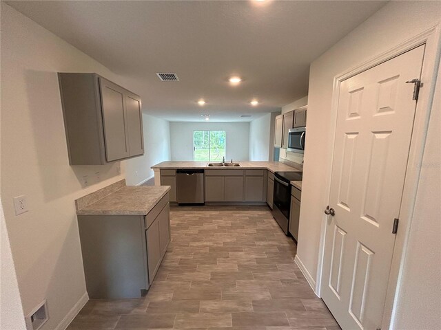 70 Karas Trl, Palm Coast, FL 32164 - kitchen with recessed lighting, gray cabinetry, visible vents, a sink, and appliances with stainless steel finishes