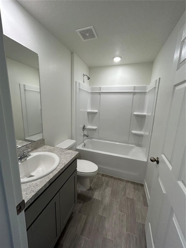 70 Karas Trl, Palm Coast, FL 32164 - bathroom with toilet, wood finished floors, vanity, visible vents, and washtub / shower combination