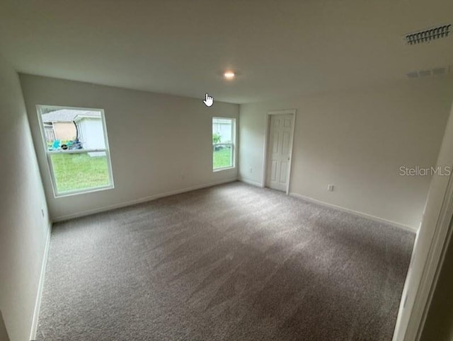 unfurnished room featuring carpet floors and baseboards