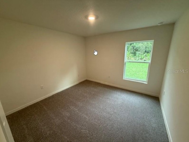 carpeted empty room with baseboards