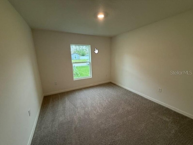 empty room featuring carpet floors and baseboards