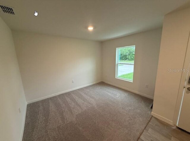 carpeted spare room featuring baseboards and recessed lighting