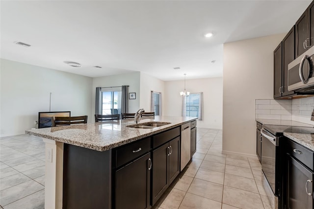 1443 SW 1st St, Cape Coral, FL 33991 - kitchen with appliances with stainless steel finishes, a sink, light tile patterned floors, light stone counters, and recessed lighting